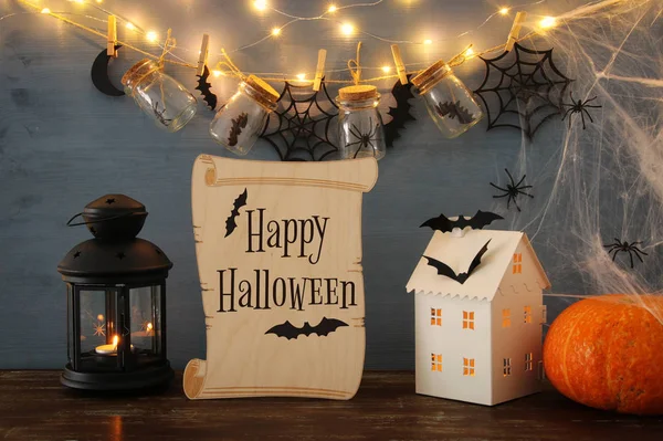 Concetto di festa di Halloween. Misteriosa casa con luci di fronte a vasi di massoni con ragni e bagni — Foto Stock