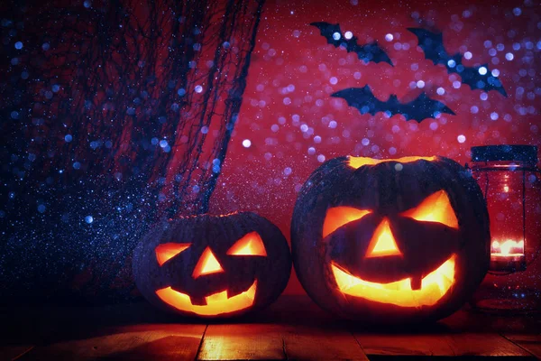 Calabaza de Halloween en la mesa de madera frente al espeluznante fondo oscuro. Jack o linterna —  Fotos de Stock