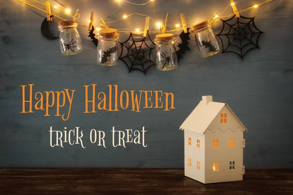 Concepto de Halloween. Casa misteriosa con luces en frente de tarros de Masson con arañas, baños — Foto de Stock