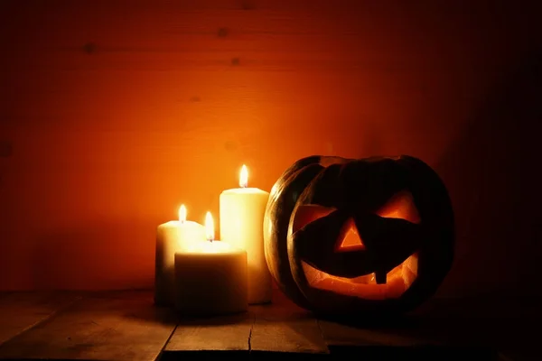 Zucca di Halloween sul tavolo di legno di fronte a sfondo scuro spettrale. Jack o lanterna — Foto Stock