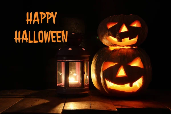Calabaza de Halloween en la mesa de madera frente al espeluznante fondo oscuro. Jack o linterna —  Fotos de Stock