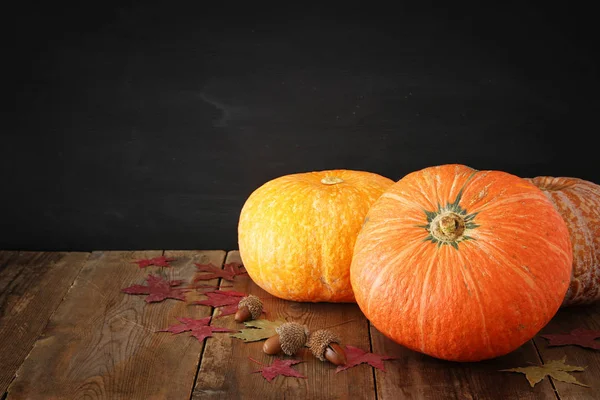 Pompoenen en herfst laat op houten achtergrond. Thanksgiving en halloween concept — Stockfoto