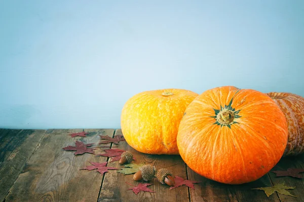 Pompoenen en herfst laat op houten achtergrond. Thanksgiving en halloween concept — Stockfoto