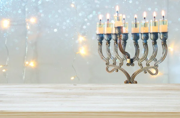 Mesa de madeira vazia na frente de férias judaicas Hanukkah fundo com menorah (candelabros tradicionais ) — Fotografia de Stock