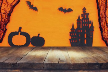 Cadılar Bayramı tatil kavramı boş rustik masa üzerinde turuncu arka plan ile. Ürün görüntü montaj için hazır