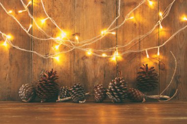 Tatil görüntü ile Noel altın çelenk ışık ve çam kozalakları ahşap arka plan üzerinde