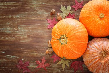 Kabaklar ve sonbahar yaprakları üzerinde ahşap arka plan. Şükran günü ve Cadılar Bayramı kavramı. Üstten Görünüm.