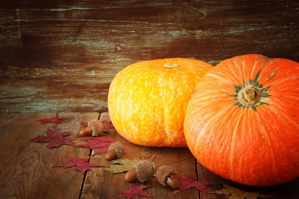 Pompoenen en herfst laat op houten achtergrond. Thanksgiving en halloween concept. Bovenaanzicht. — Stockfoto
