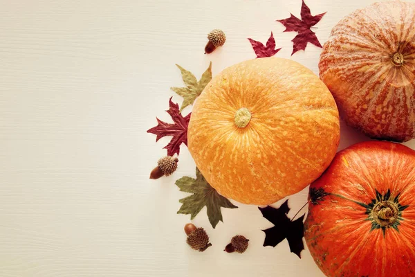 Pompoenen en herfst laat op houten achtergrond. Thanksgiving en halloween concept. Bovenaanzicht. — Stockfoto