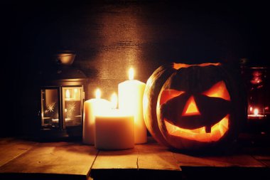 Cadılar Bayramı Balkabağı korkunç koyu arka plan önünde tahta masada. Jack o fener