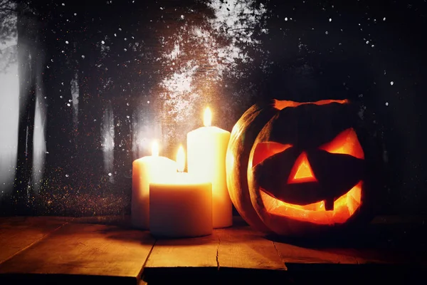 Zucca di Halloween sul tavolo di legno di fronte a sfondo scuro spettrale. Jack o lanterna — Foto Stock