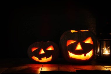 Cadılar Bayramı Balkabağı korkunç koyu arka plan önünde tahta masada. Jack o fener