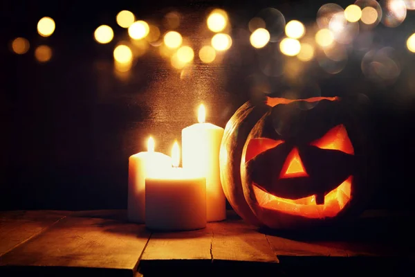 Zucca di Halloween sul tavolo di legno di fronte a sfondo scuro spettrale. Jack o lanterna — Foto Stock