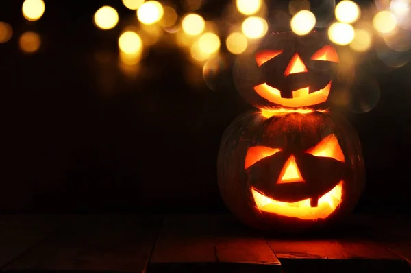 Halloween pompoen op houten tafel spooky donkere achtergrond. Jack o lantern — Stockfoto