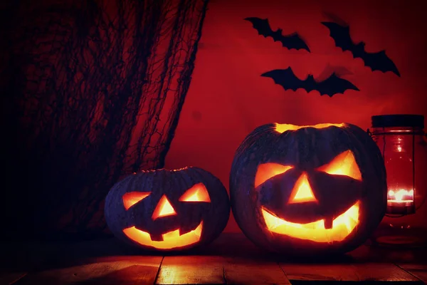 Calabaza de Halloween en la mesa de madera frente al espeluznante fondo oscuro. Jack o linterna — Foto de Stock