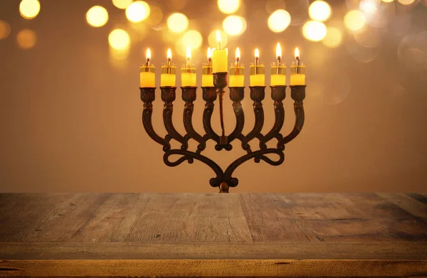 Lege houten tafel voor Joodse vakantie Hanukkah achtergrond met menora (traditionele kandelaar) — Stockfoto