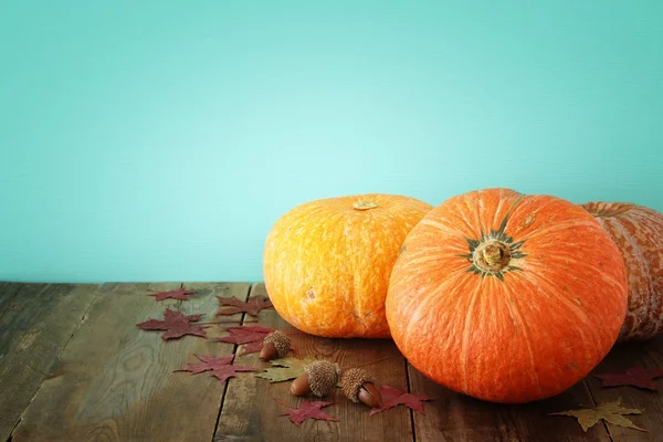 Pompoenen en herfst laat op houten achtergrond. Thanksgiving en halloween concept — Stockfoto