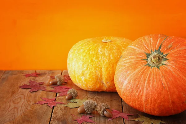 Kabaklar ve sonbahar yaprakları üzerinde ahşap arka plan. Şükran günü ve Cadılar Bayramı kavramı