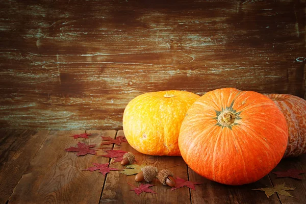 Pompoenen en herfst laat op houten achtergrond. Thanksgiving en halloween concept — Stockfoto