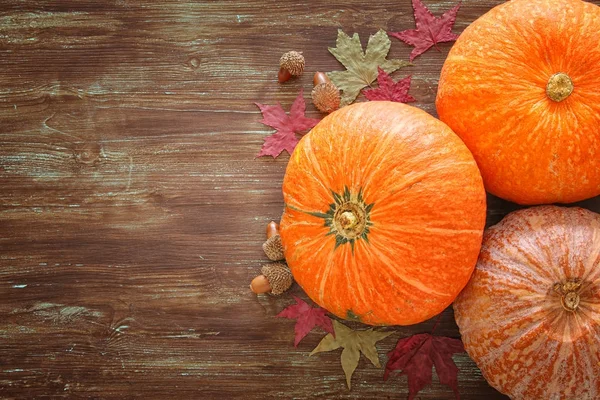 Pompoenen en herfst laat op houten achtergrond. Thanksgiving en halloween concept — Stockfoto