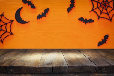 Cadılar Bayramı tatil kavramı boş rustik masa üzerinde turuncu arka plan ile. Ürün görüntü montaj için hazır