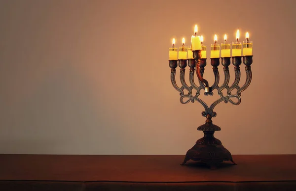 Low key image of jewish holiday Hanukkah background with menorah (traditional candelabra) and burning candles — Stock Photo, Image