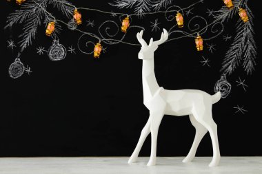 Ahşap masa üzerinde el ile kara tahta arka plan üzerinde beyaz Ren geyiği tebeşir illüstrasyonlar çizilmiş.