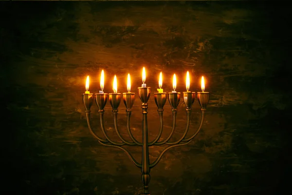 Låg nyckel bild av judiska högtiden Hanukkah bakgrund med menorah (traditionella kandelabrar) och brinnande ljus — Stockfoto