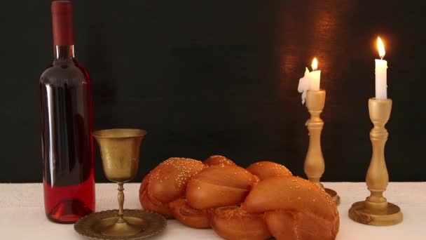 Фальшиві кадри. виклик хліба, шабатне вино і свічки на столі — стокове відео