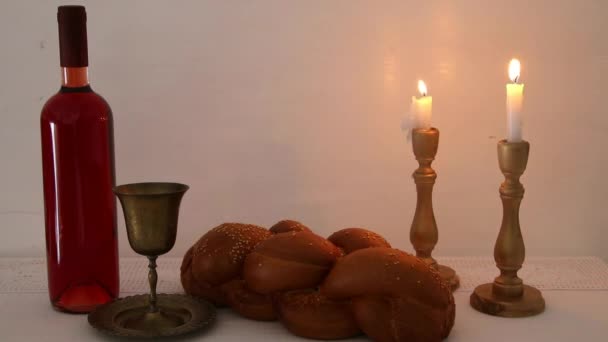 Filmagem de shabbat. pão de chalá, vinho shabbat e velas sobre a mesa — Vídeo de Stock