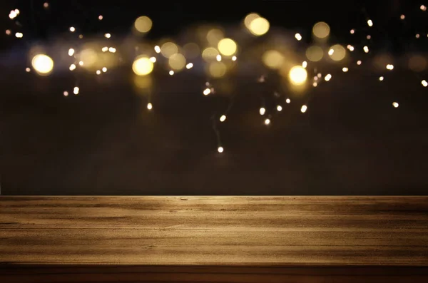 Mesa vazia na frente de luzes de brilho preto e dourado fundo — Fotografia de Stock