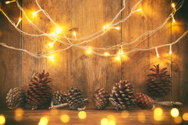 Tatil görüntü ile Noel altın çelenk ışık ve çam kozalakları ahşap arka plan üzerinde