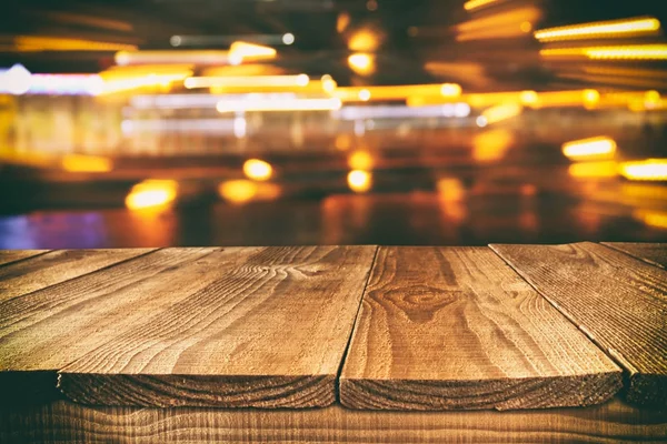 Gambar meja kayu di depan latar belakang lampu restoran yang kabur dan abstrak — Stok Foto