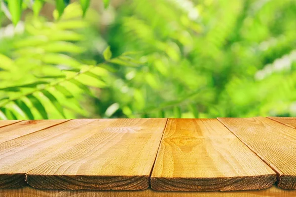 Ξύλινο τραπέζι μπροστά από τροπικό πράσινο floral φόντο. για απεικόνιση και παρουσίαση προϊόντων. — Φωτογραφία Αρχείου