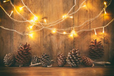 Tatil görüntü ile Noel altın çelenk ışık ve çam kozalakları ahşap arka plan üzerinde