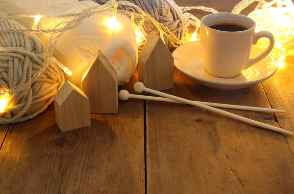 Boules de laine chaudes et confortables et tasse de café chaude sur une table en bois — Photo