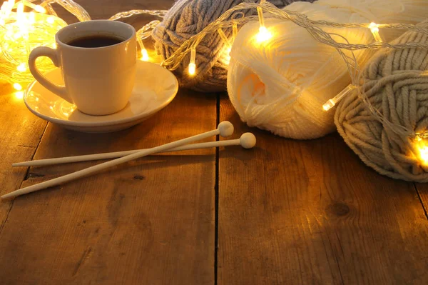 Boules de laine chaudes et confortables et tasse de café chaude sur une table en bois — Photo