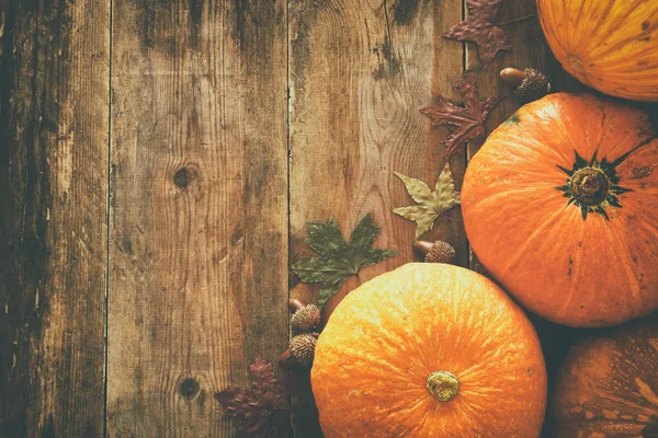 Pompoenen en herfst laat op houten achtergrond. Thanksgiving en halloween concept — Stockfoto