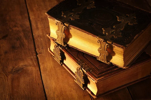 Antique books, with brass clasps on old wooden table. fantasy medieval period and religious concept — Stock Photo, Image