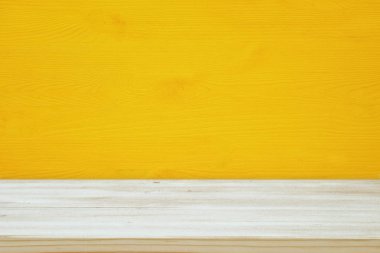 Sarı ahşap arka plan önünde boş bir tablo. Ürün görüntü montaj için