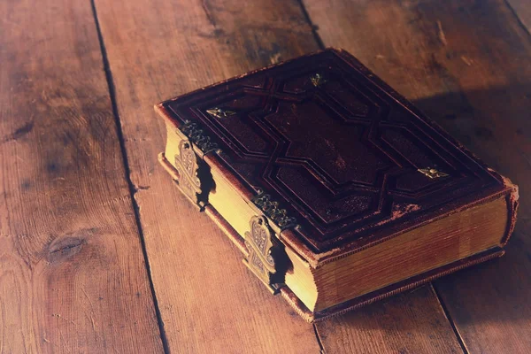 Antique books, with brass clasps on old wooden table. fantasy medieval period and religious concept — Stock Photo, Image