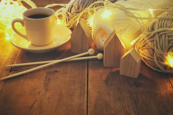 Boules de laine chaudes et confortables et tasse de café chaude sur une table en bois . — Photo