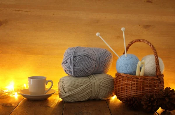 羊毛和杯热咖啡木制的桌子上的温暖和舒适的毛线球. — 图库照片