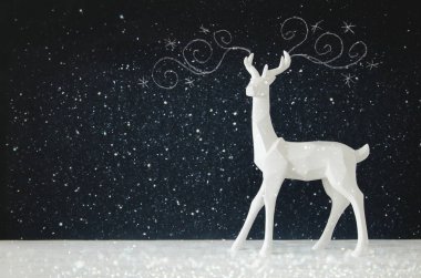 Kara tahta arka plan whith el üzerinde ahşap masa üzerinde beyaz Ren geyiği tebeşir illüstrasyonlar çizilmiş