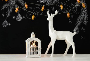 Ahşap masa üzerinde el ile kara tahta arka plan üzerinde beyaz Ren geyiği tebeşir illüstrasyonlar çizilmiş.