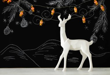 Ahşap masa üzerinde el ile kara tahta arka plan üzerinde beyaz Ren geyiği tebeşir illüstrasyonlar çizilmiş.