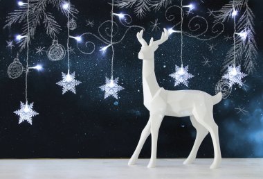 Ahşap masa üzerinde el ile kara tahta arka plan üzerinde beyaz Ren geyiği tebeşir illüstrasyonlar çizilmiş.