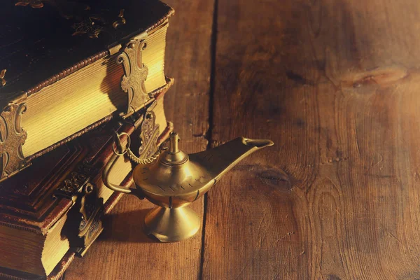 Image of magical aladdin lamp and old books. Lamp of wishes.
