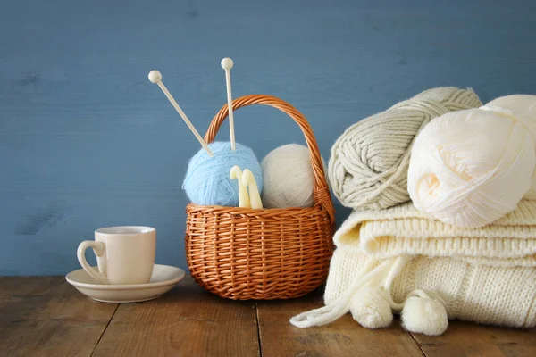 Cálidas y acogedoras bolas de lana y taza de café caliente en la mesa de madera . —  Fotos de Stock