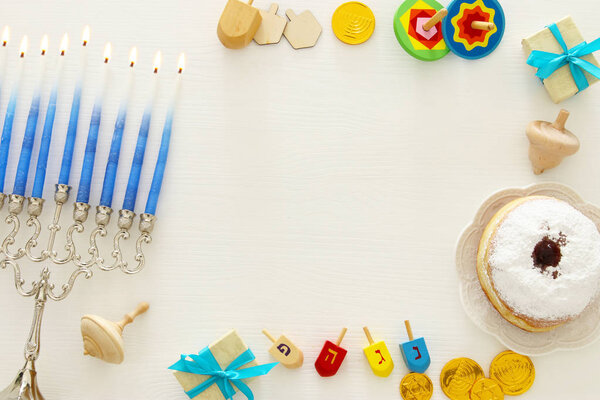 Top view image of jewish holiday Hanukkah background with traditional spinnig top, menorah (traditional candelabra)